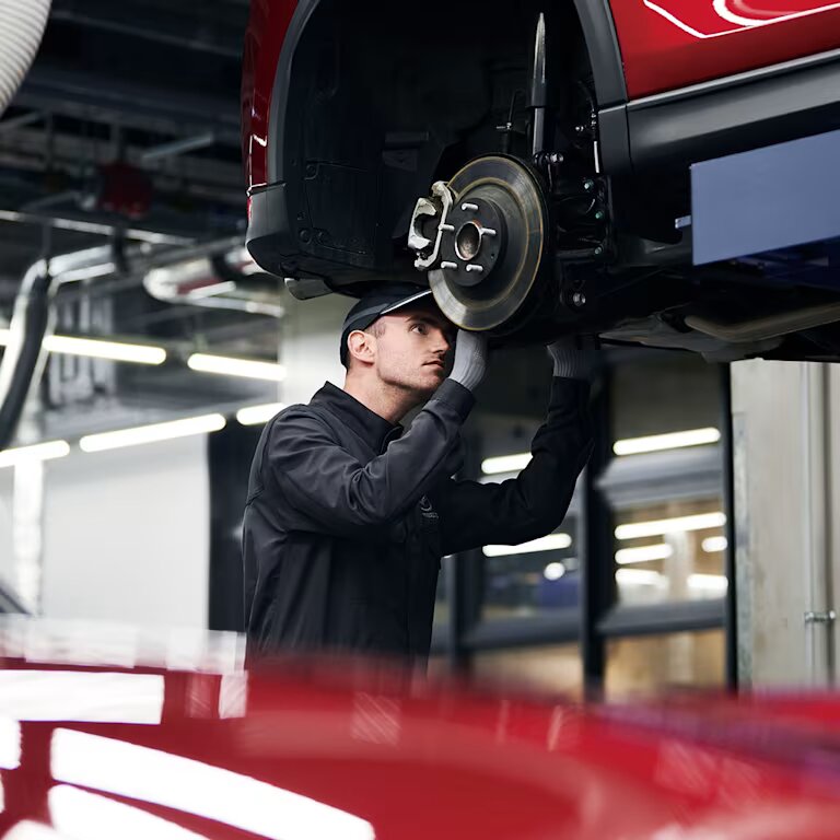 Mechaniker arbeitet an einem Auto auf der Hebebühne